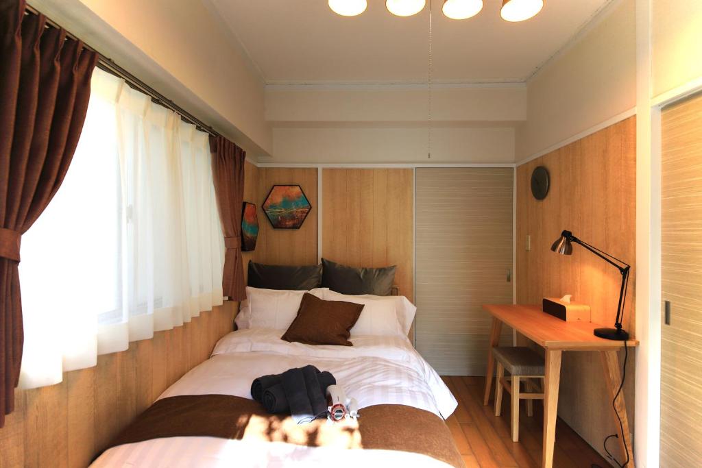 1 dormitorio con cama y escritorio. en FUJITAKI CORP, en Tokio