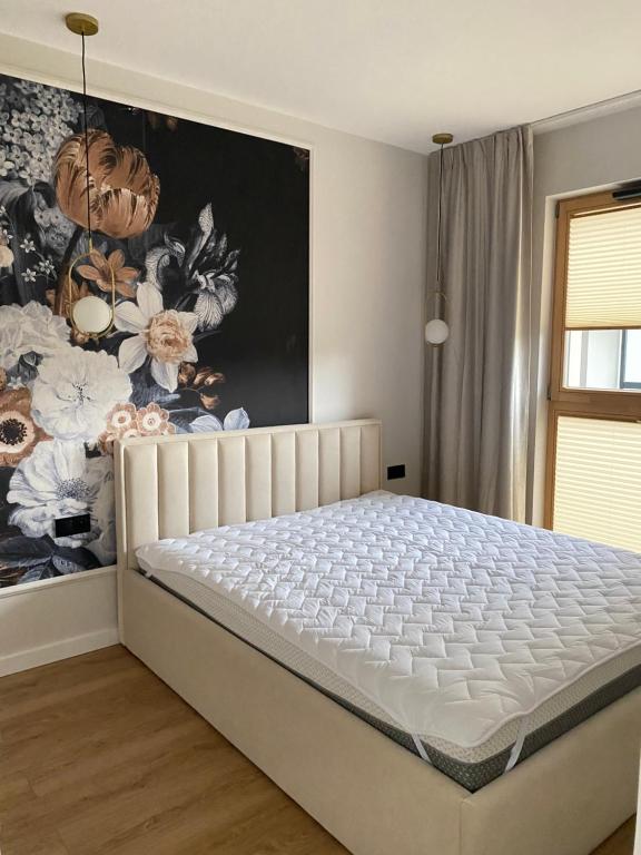 een bed in een slaapkamer met een schilderij aan de muur bij Apartament PORTO in Gdańsk