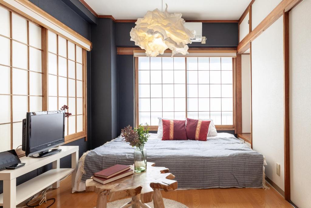 um quarto com uma cama e uma secretária com uma televisão em Hills Komagome em Tóquio