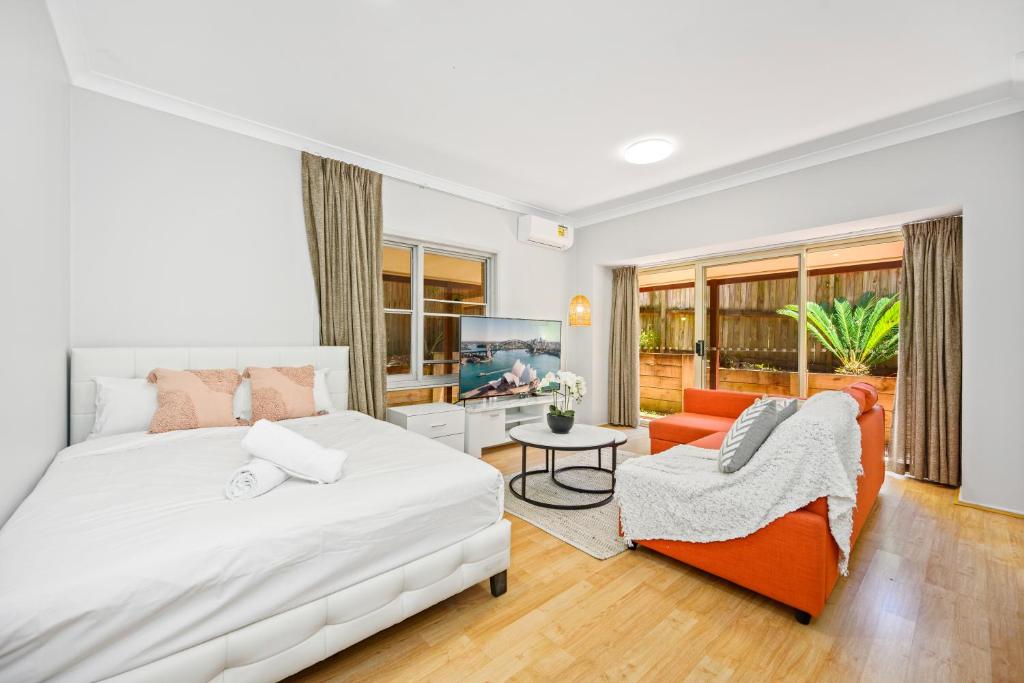 ein weißes Schlafzimmer mit einem Bett und einem Sofa in der Unterkunft Marsfield 5 bed Townhouse near Macquarie Uni FreeP in Sydney