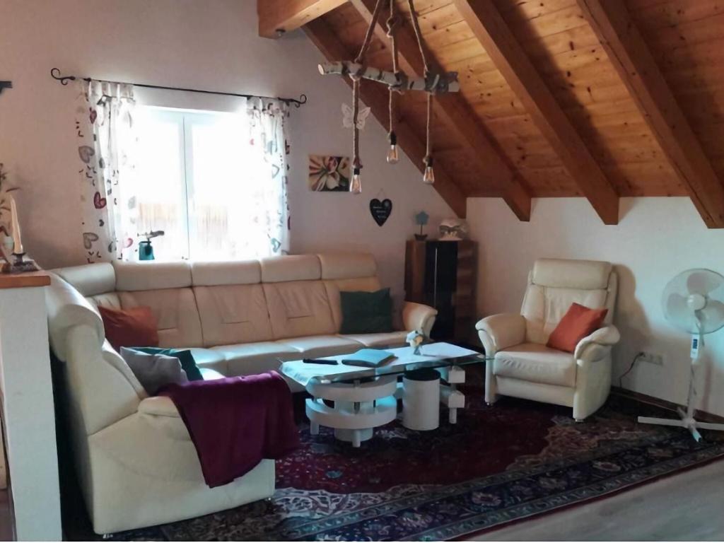 sala de estar con sofá, mesa y sillas en Holiday apartment near Lake Klopeiner with sauna, en Neuhaus