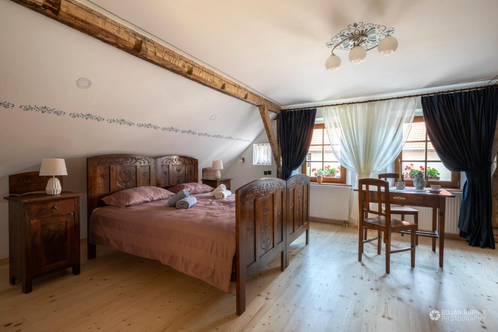 Begunje pri CerkniciにあるNotranjska hiša - traditional country house, close to the world attraction Cerknica lakeのベッドルーム1室(ベッド1台、テーブル、椅子付)