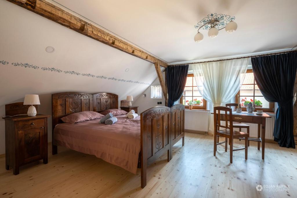 a bedroom with a bed and a table and chairs at Notranjska hiša - traditional country house, close to the world attraction Cerknica lake in Begunje pri Cerknici