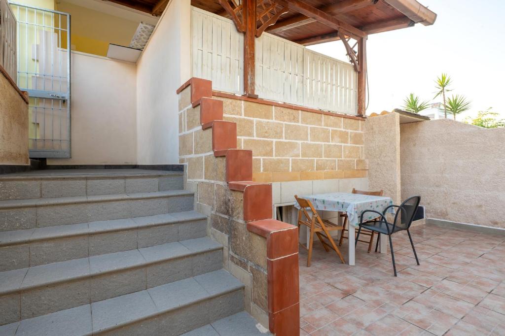un mur en briques avec une table et des chaises sur la terrasse dans l'établissement Appartamento Acquadolce n 2, à Torre Ovo