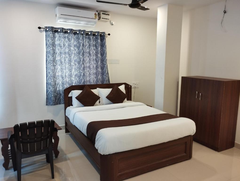 a bedroom with a bed and a chair and a window at HOTEL VIRAT GRAND in Hyderabad