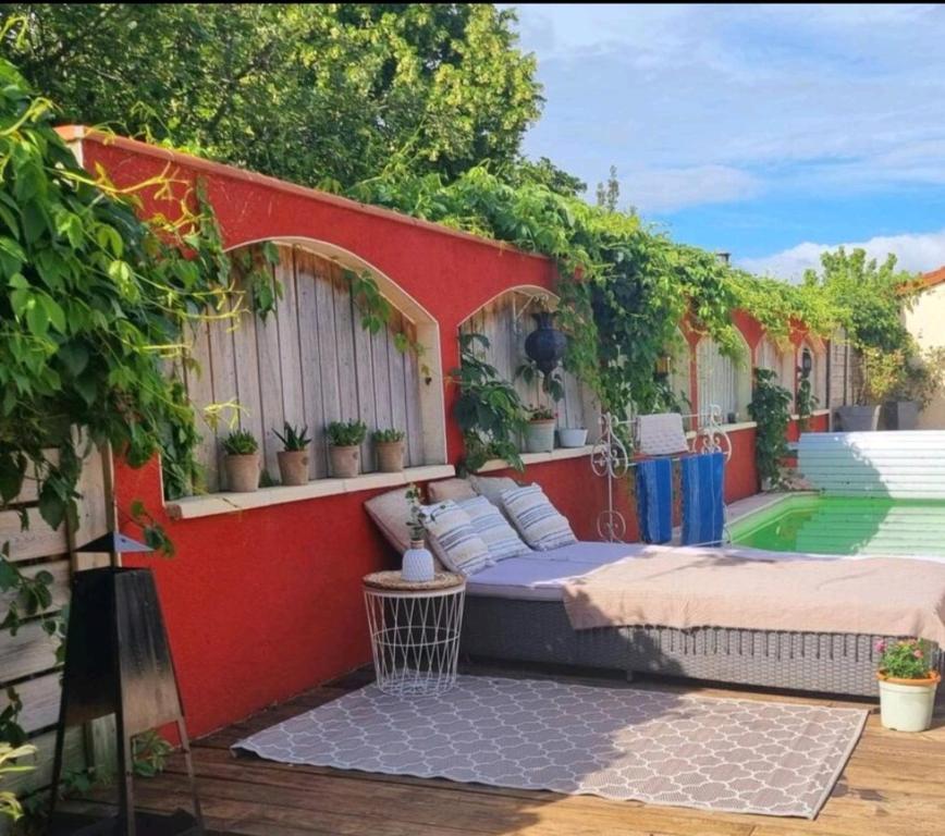 eine Terrasse mit einem Bett und Pflanzen darauf in der Unterkunft Le beauplan in Chalain-le-Comtal