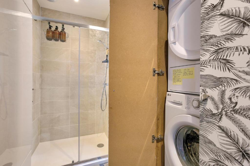 a washing machine in a bathroom with a shower at Bella Cruz - Charmant appt à Dinard in Dinard