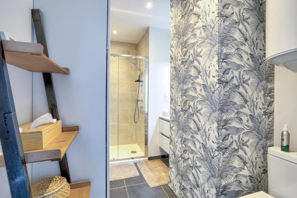 a bathroom with a shower and a shower curtain at Bella Cruz - Charmant appt à Dinard in Dinard