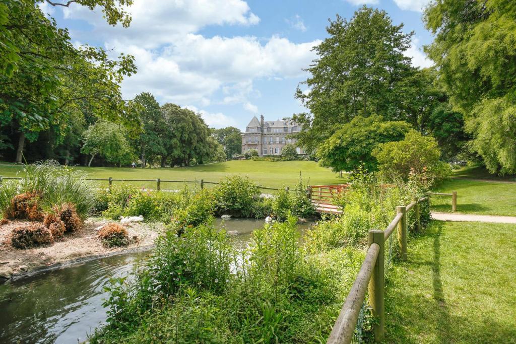 a garden with a pond in front of a house at Bella Cruz - Charmant appt à Dinard in Dinard