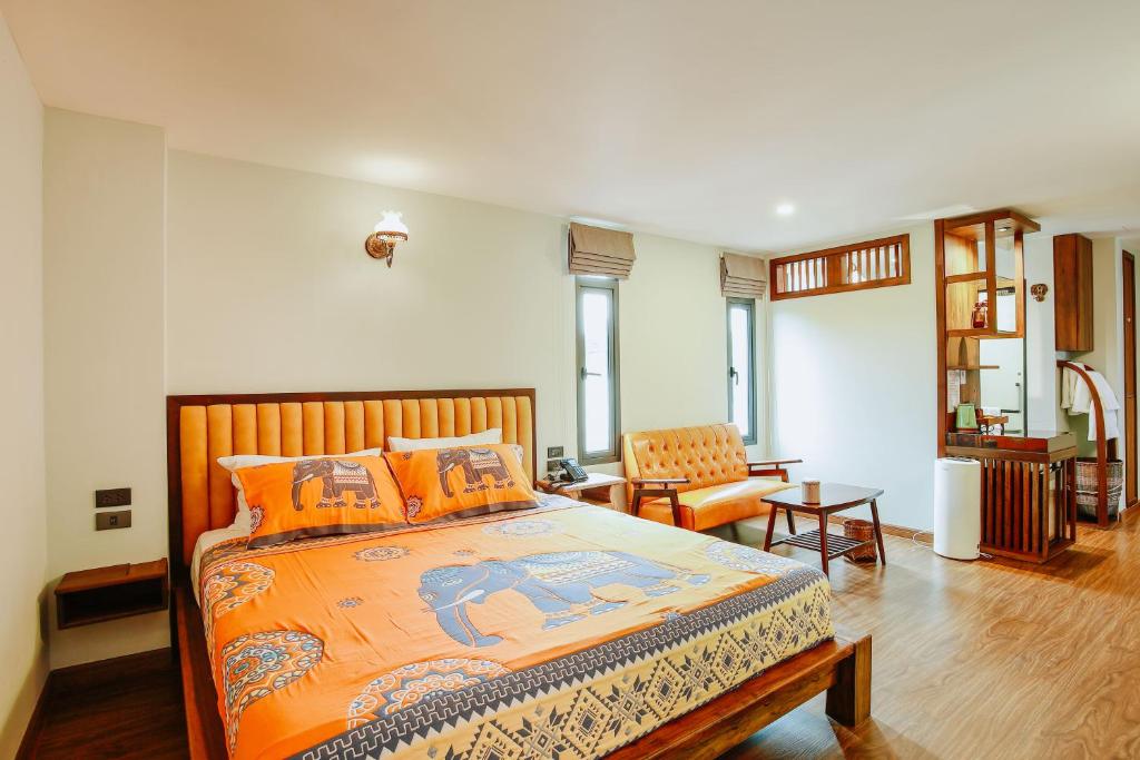 a bedroom with a large bed with orange pillows at WangChang Hotel Chiang Mai โรงแรมวังช้าง เชียงใหม่ in Chiang Mai