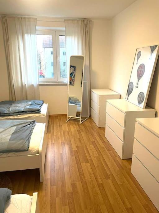 - une chambre avec 2 lits et quelques commode dans l'établissement Messe - Augsburg - Zentrum - 2 Zimmer - 3 Personen, à Augsbourg