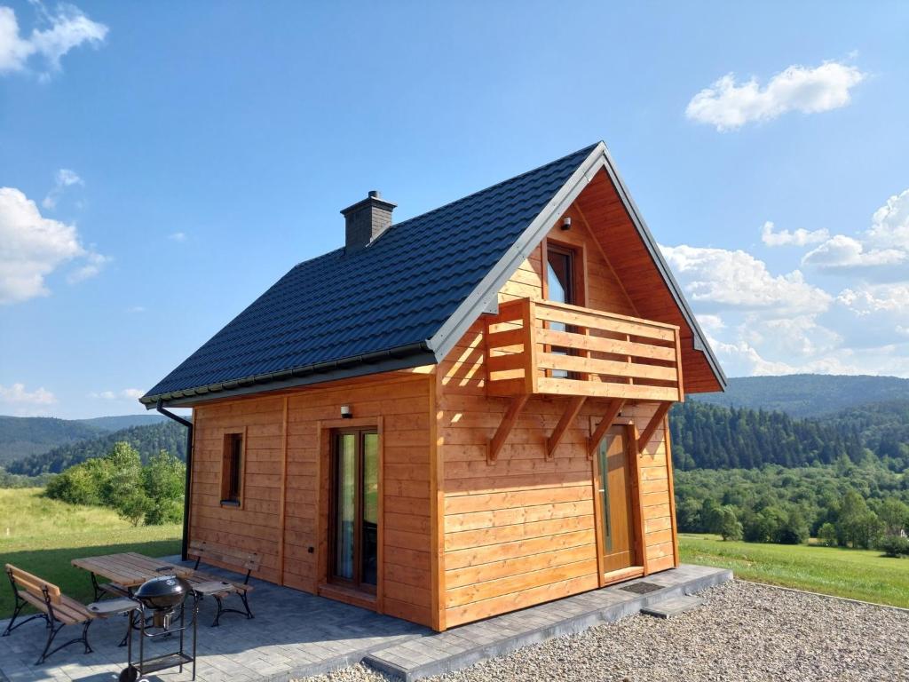 ein winziges Haus mit einem Dach auf einer Terrasse in der Unterkunft Domek Rodakówka in Krempna