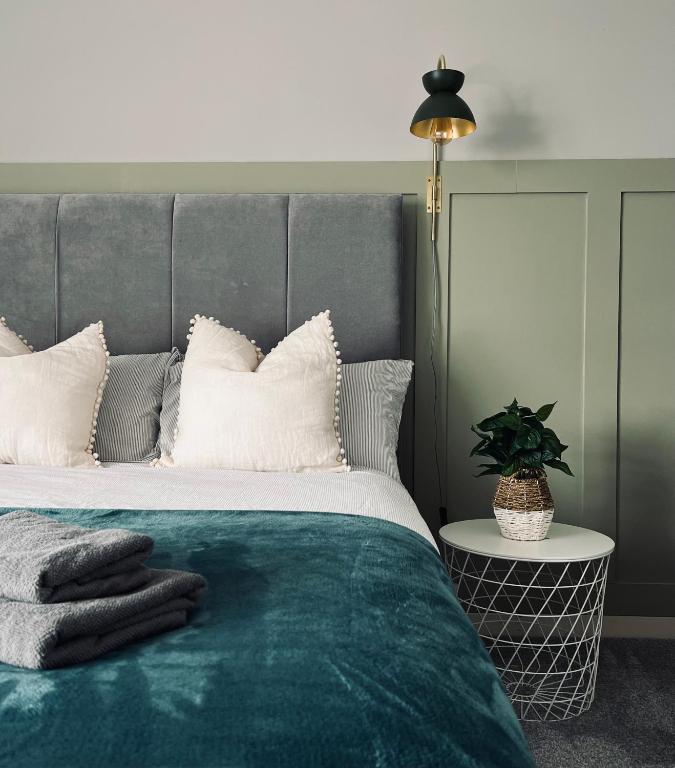 1 dormitorio con 1 cama grande con manta verde en Modern 2-bed flat in town centre, en Oban