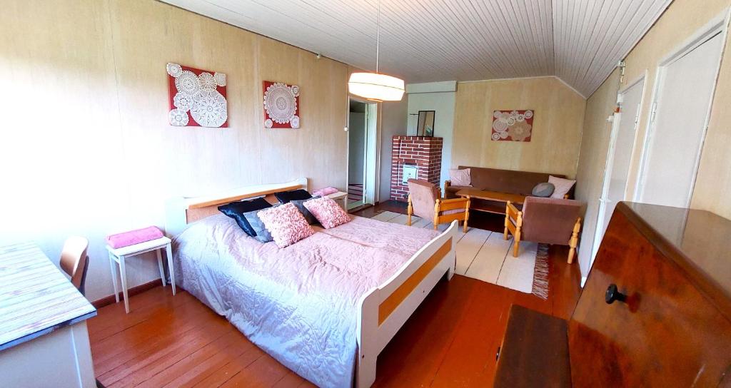 a bedroom with a bed and a desk in it at Villa Mummola Neljän makuuhuoneen asunto lähellä jokea in Simpele