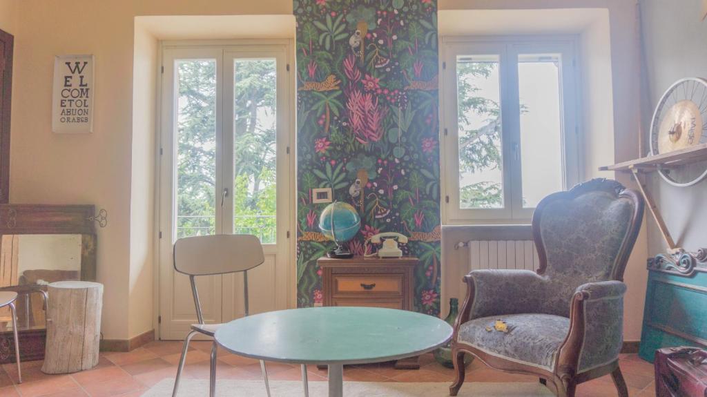 ein Wohnzimmer mit einem Tisch und einem Stuhl in der Unterkunft B&B La Buonora in Sinio