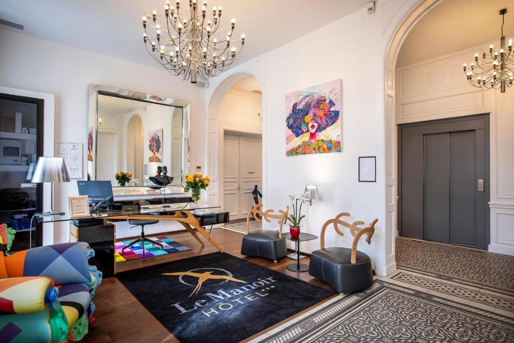 a living room with a chandelier and a couch at Le Manoir Hotel, BW Signature Collection in La Rochelle