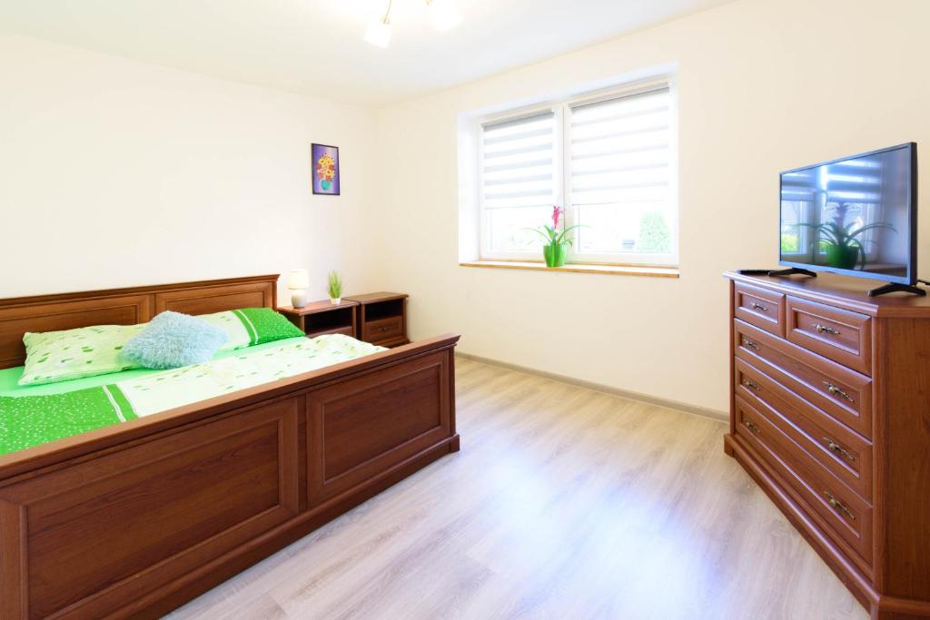 een slaapkamer met een groot houten bed en een dressoir bij Pokój gościnny 