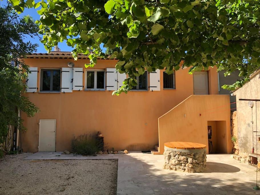 ein orangenes Haus mit einer Bank davor in der Unterkunft ''Mon brin de Lavande'' By Miss.K Conciergerie in Auriol