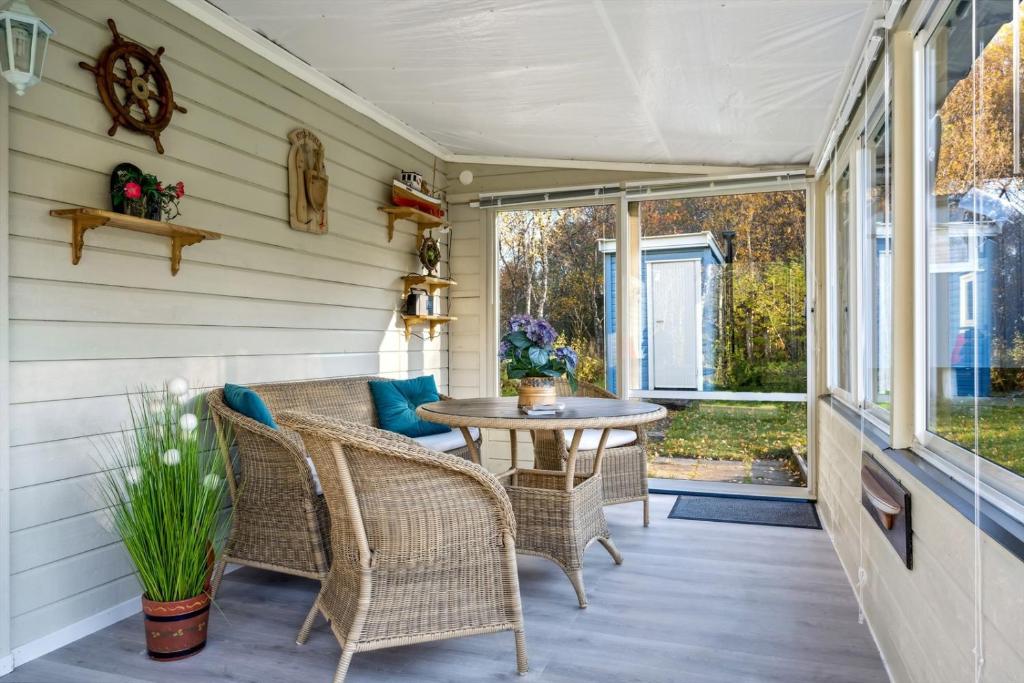 una veranda con sedie in vimini e tavolo di Hytte i Saltstraumen a Bodø