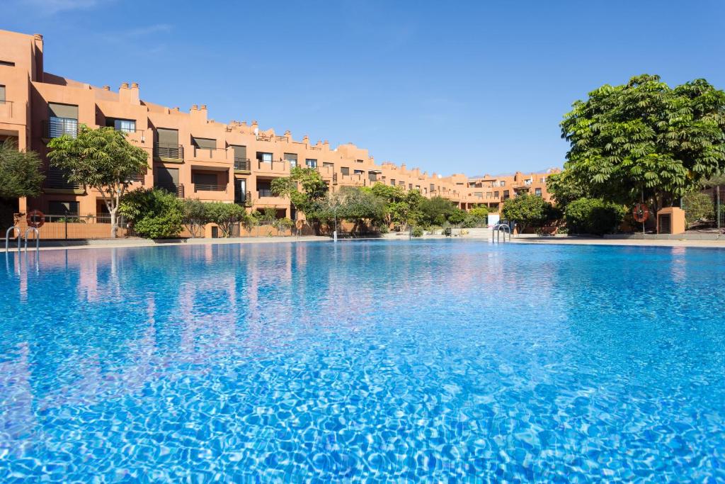 uma grande piscina de água azul com edifícios ao fundo em 123 Sotavento Beach and Sun By Sunkeyrents em La Tejita