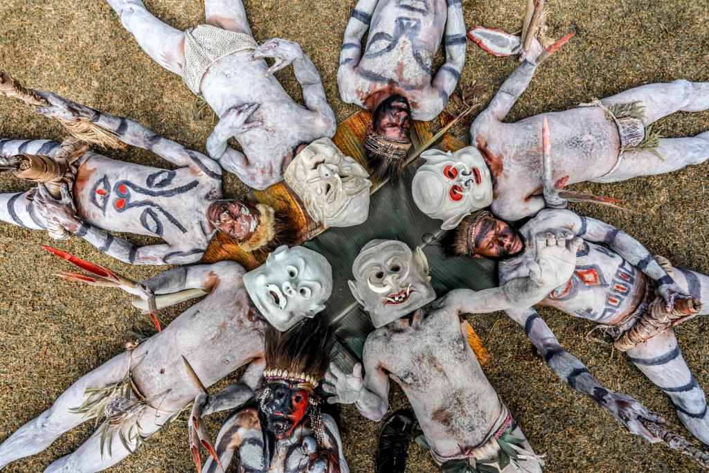 a group of zombies laying on the ground at The Asaro Mudmen Tribal Eco Lodge 