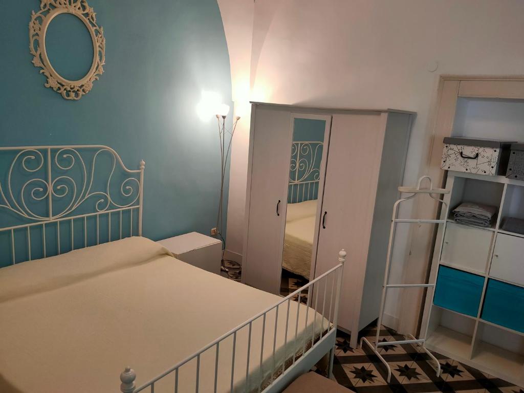 małą sypialnię z łóżkiem i lustrem w obiekcie Suite San Giovanni w mieście Torre Santa Susanna
