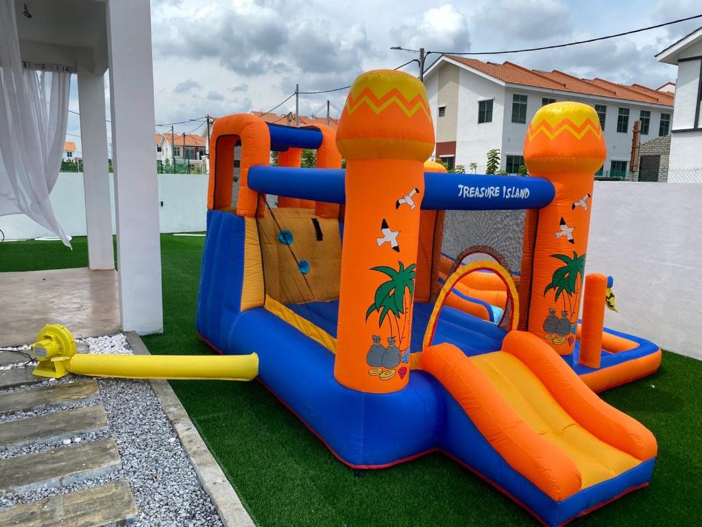 un parque infantil con juegos anaranjados y azules en Rumatepi, en Melaka