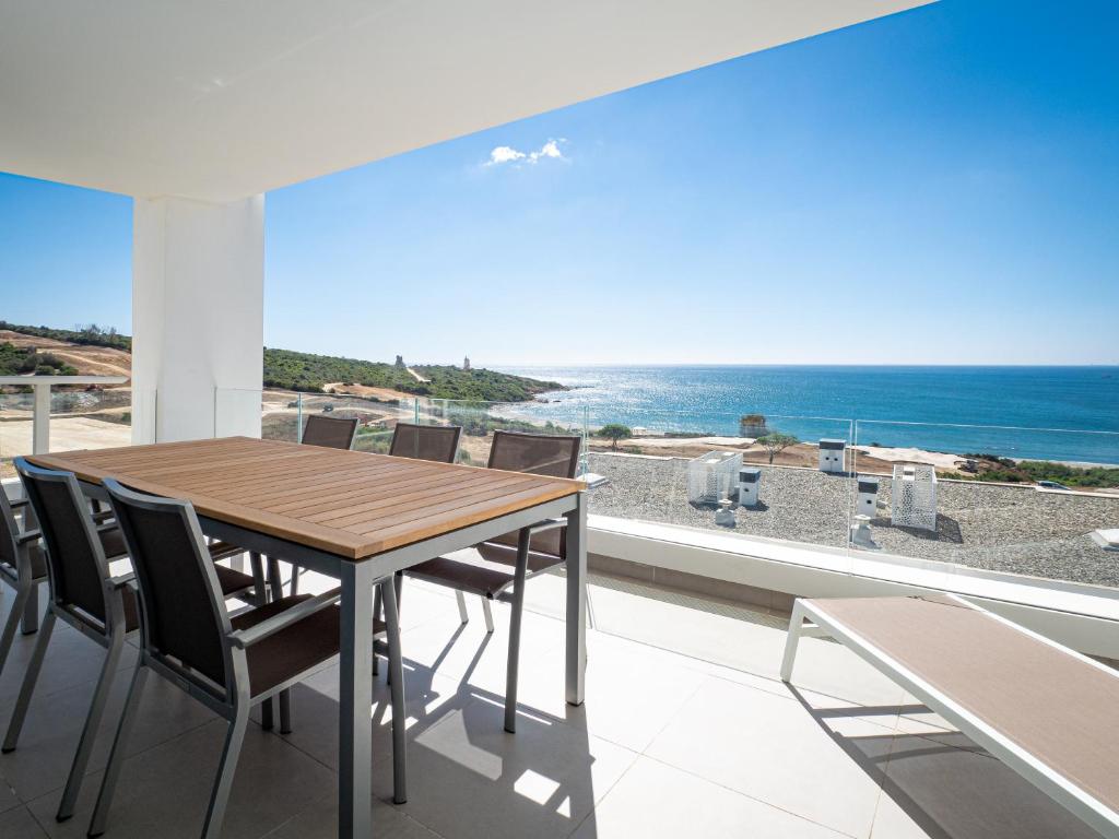 uma sala de jantar com uma mesa e vista para o oceano em Links II Sea & SPA by JC Homes em Alcaidesa