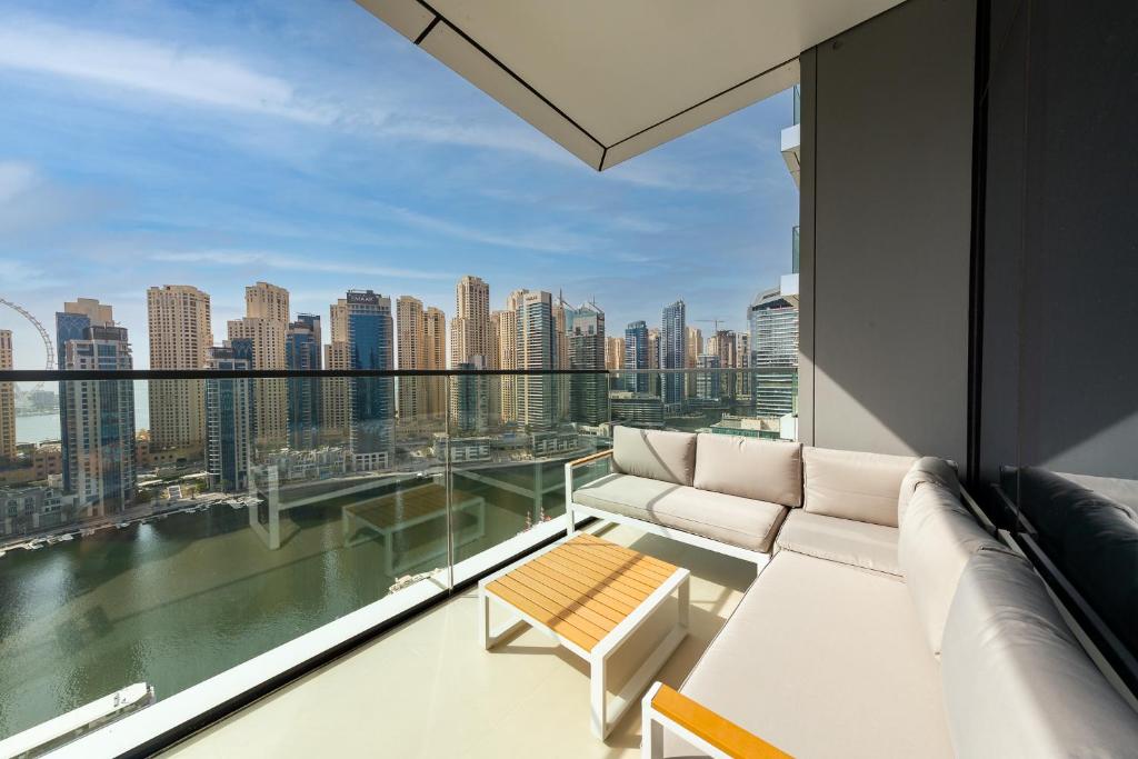 a balcony with a couch and a view of the city at BRAND-NEW 1 Bedroom with full Marina View in Dubai