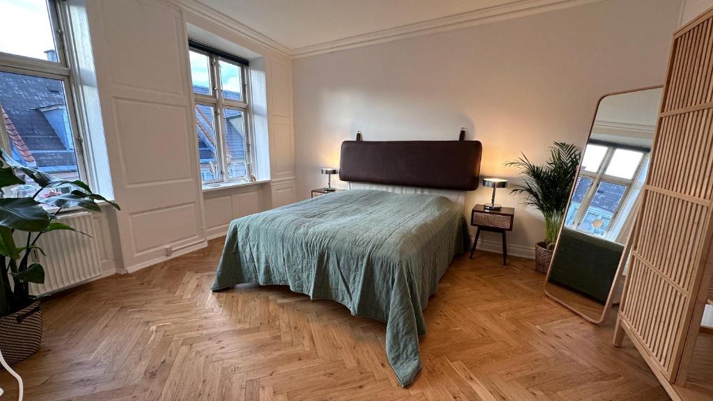 1 dormitorio con 1 cama en una habitación con ventanas en Carolinas Apartment - Studiestæde 3, en Copenhague