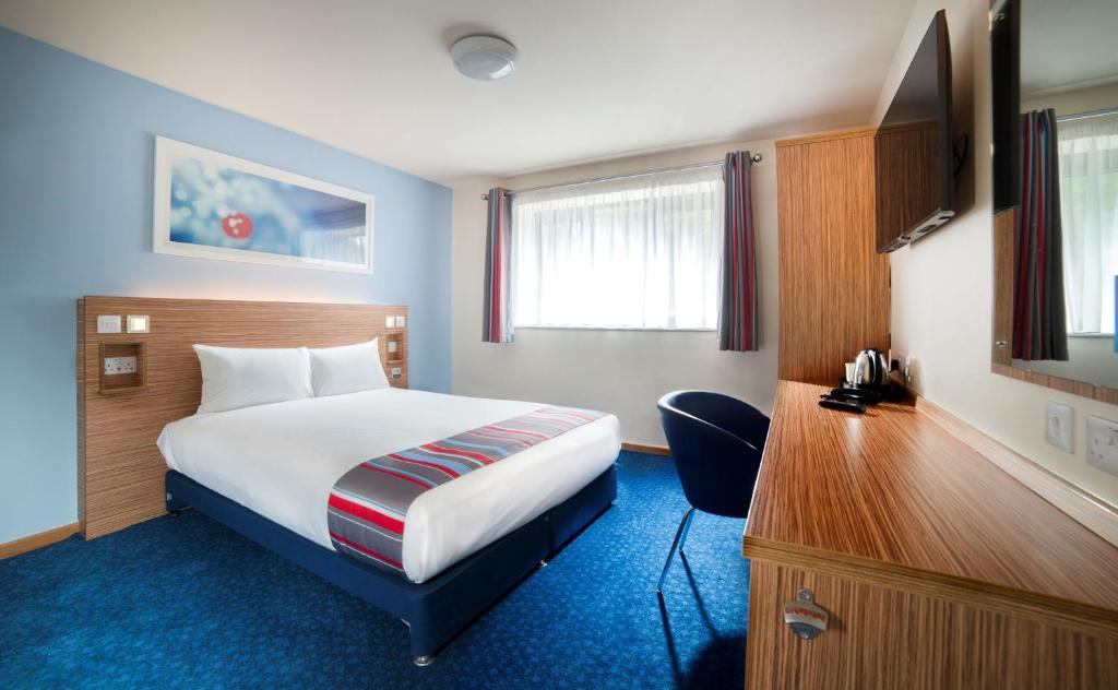 una camera d'albergo con un letto e una scrivania di Travelodge Dublin Airport North 'Swords' a Swords