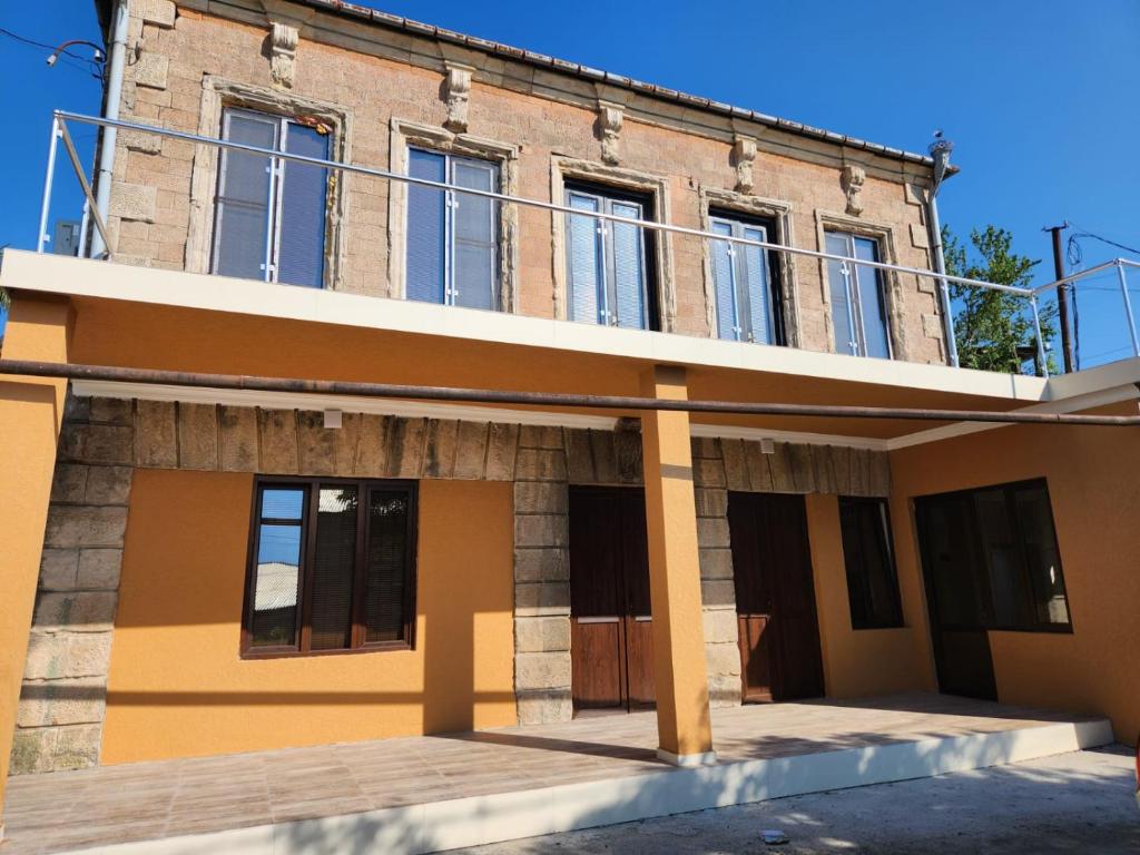 ein Backsteingebäude mit Balkon darüber in der Unterkunft Hostel VATO in Kutaissi