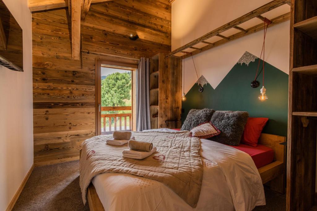 sypialnia z łóżkiem w pokoju z drewnianymi ścianami w obiekcie Chez L'Angèle w mieście Les Gets
