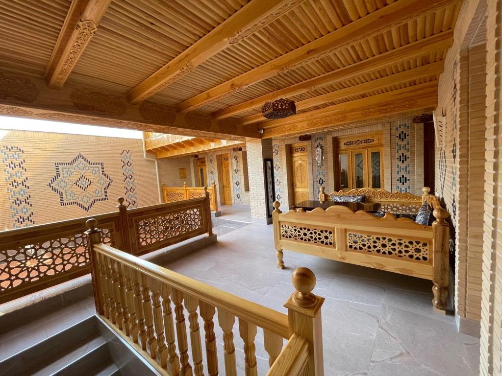 a porch with a bed and a wooden railing at Hanifa Boutique in Samarkand