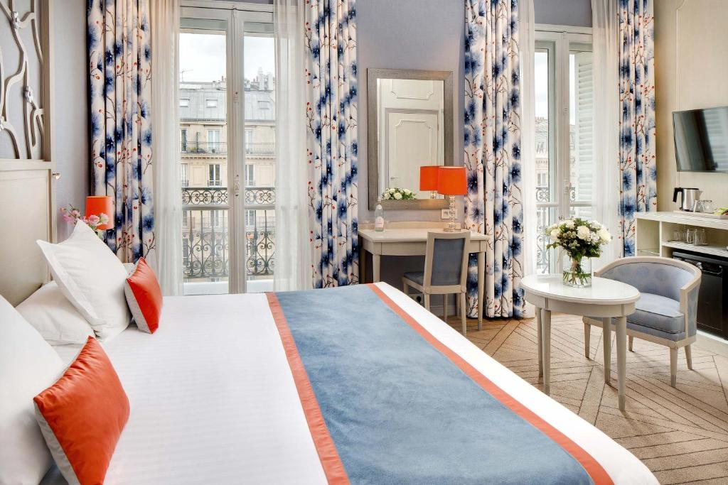 a hotel room with a large bed and a desk at Splendid Etoile in Paris