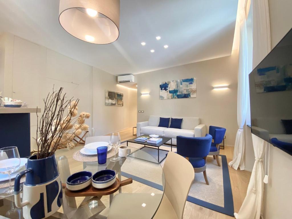 sala de estar con mesa de cristal y sillas azules en San Giorgio Uno 60mq 1b/1b en Portofino