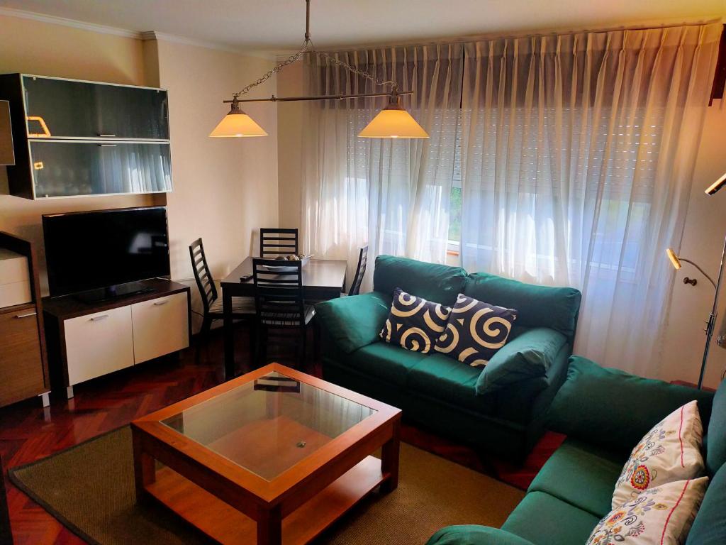 a living room with a green couch and a coffee table at Piso Corunna Easy Parking wifi in Arteixo