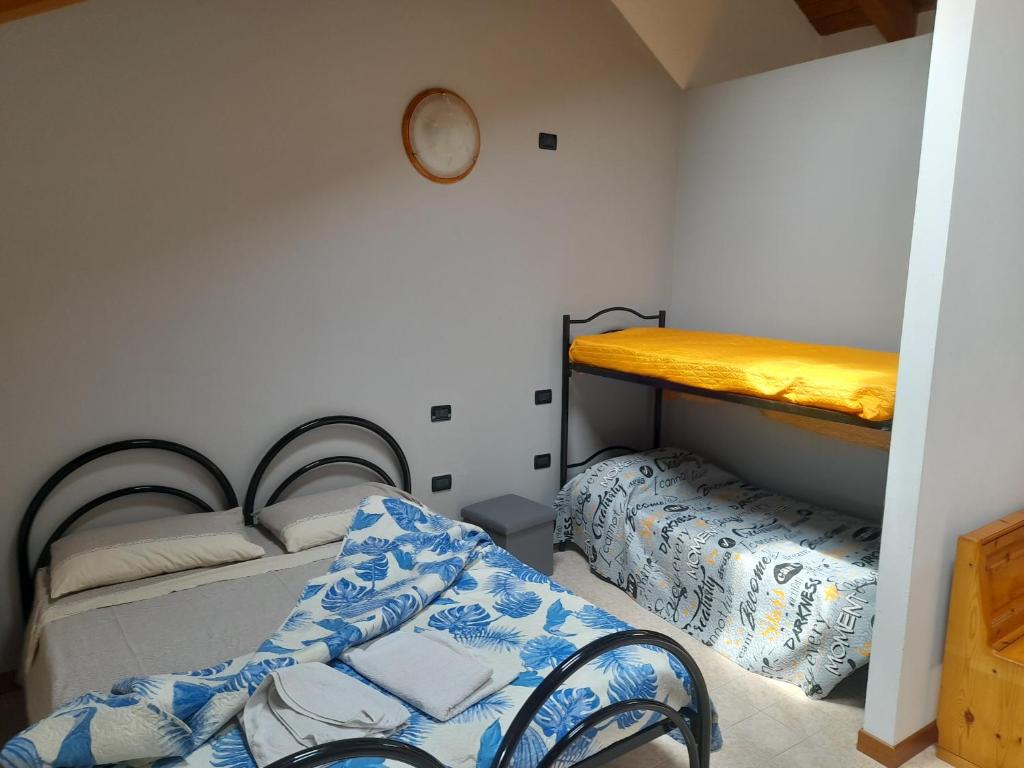 a room with two bunk beds and a bench in it at Agriturismo Val di Ferro in Arsiero