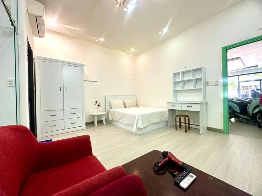 a living room with a red couch and a bed at POOLseaview - 1A Blue Sea Apart in Da Nang