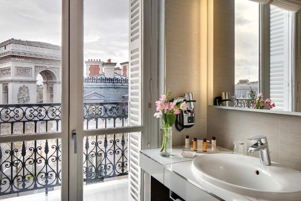 a bathroom with a sink and a window with a view at Splendid Etoile in Paris