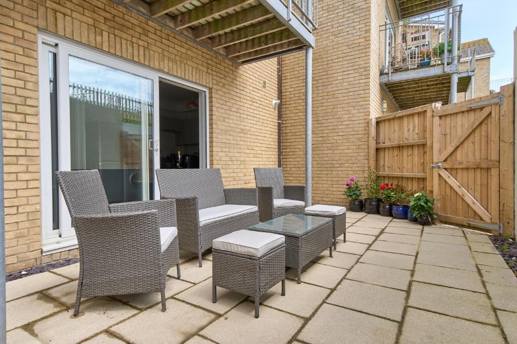 a patio with chairs and a table and a fence at Beautiful 3 Bed Apartment - Large Outside Terrace & Parking - The Perfect Choice For Families, Small Groups & Contractors - Close To Ventnor Beach in Ventnor