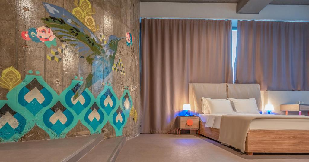 Avangarda Suites في بلغراد: غرفة نوم بسرير ودهان على الحائط