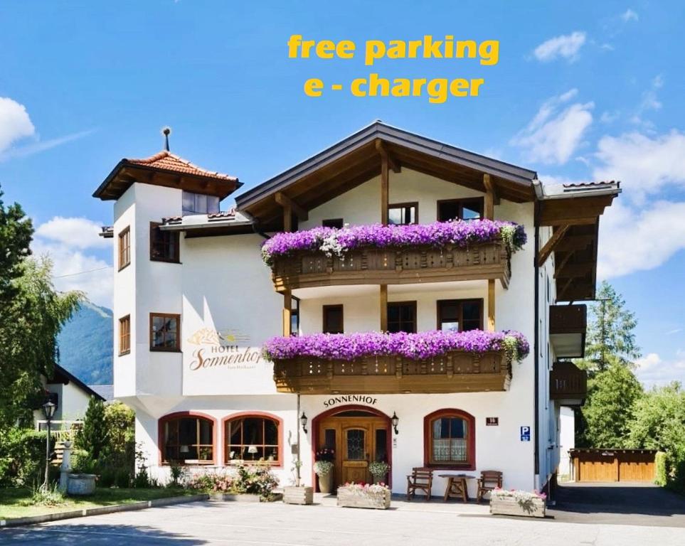 a building with purple flowers in a balcony at Hotel Sonnenhof - bed & breakfast & appartements in Innsbruck