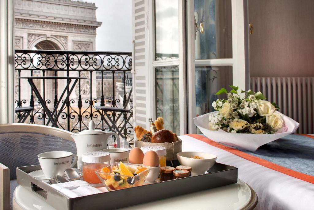 a tray with eggs and bread on a table on a balcony at Splendid Etoile in Paris