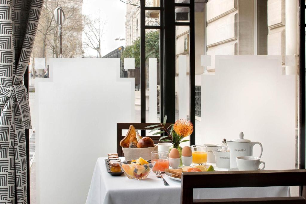 a table with a plate of food and fruit on it at Splendid Etoile in Paris