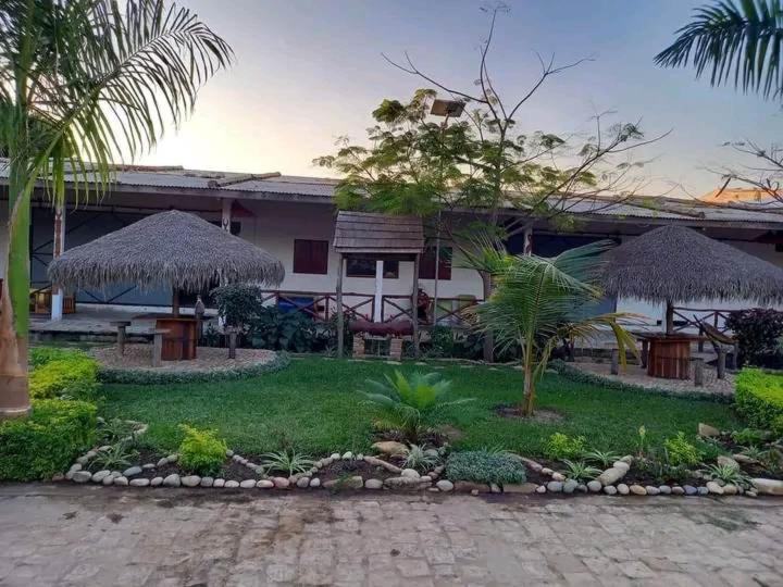 a house with a courtyard with trees and grass at Espace Menamasoandro in Morondava