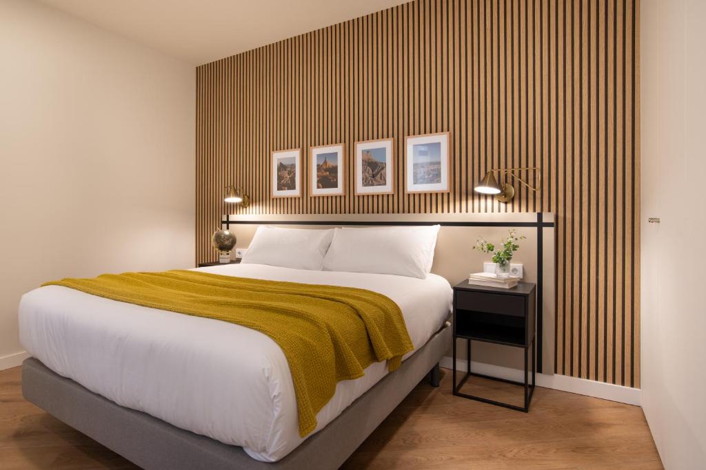 - une chambre avec un grand lit et une couverture jaune dans l'établissement Apartamentos4U Tudela Plaza Parking Incluido, à Tudela