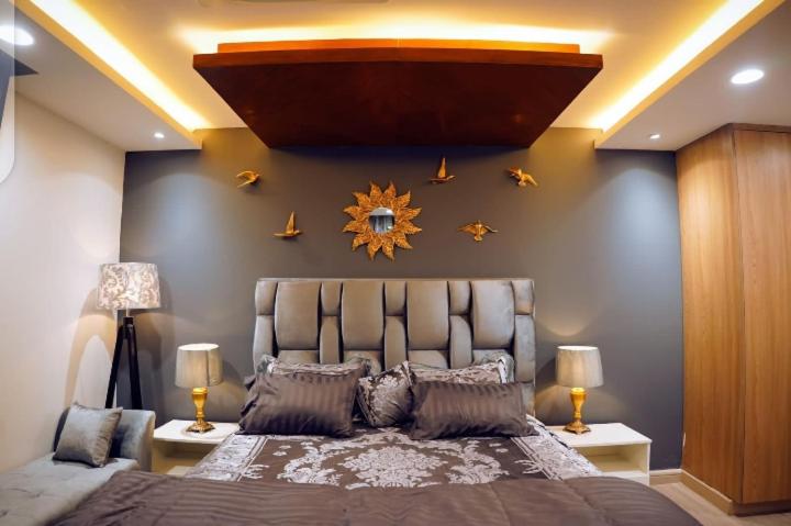 1 dormitorio con 1 cama grande en una habitación en Luxury apartment in Gold Crest Mall 1 bed, en Lahore