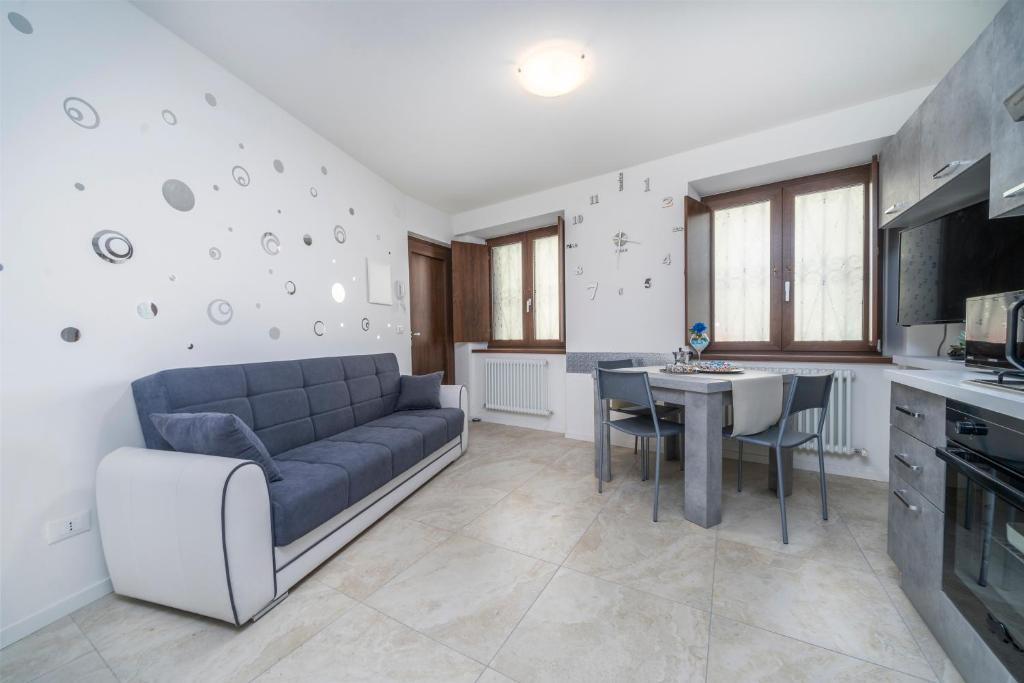 sala de estar con sofá azul y mesa en Residenza alle Grazie, en Udine