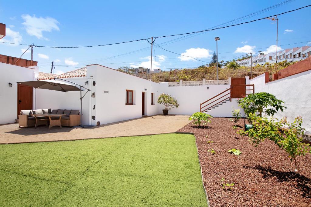a white house with a patio and a lawn at Casa Marhec in Tacoronte